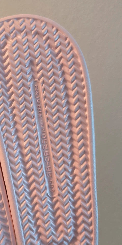 Slipper pink slides lightweight synthetic foam material with casual design.