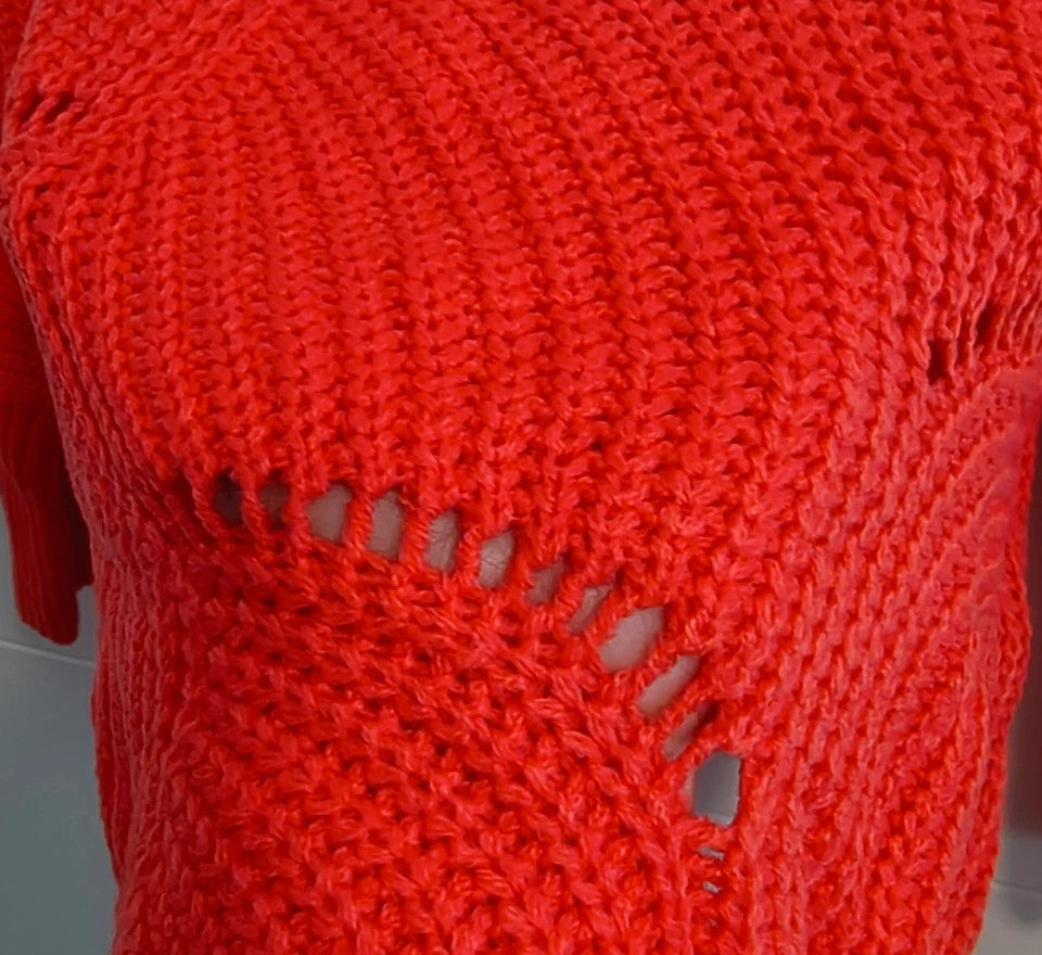 Pullover orange pink oversized sweater with decorative knit pattern and hole details.