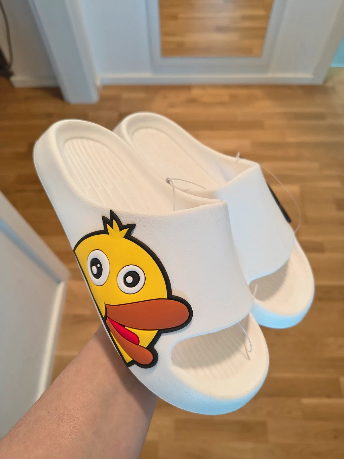 Slipper white and yellow slides with cartoon print and synthetic material.