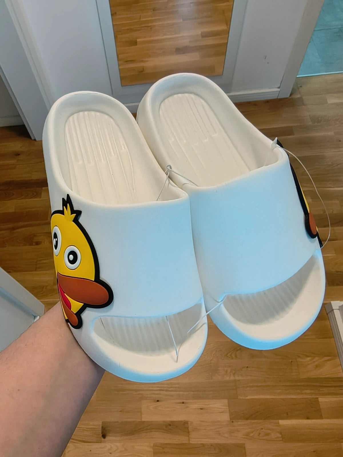 Slipper white and yellow slides with cartoon print and synthetic material.