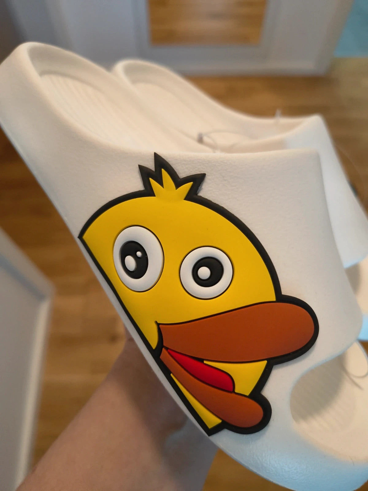 Slipper white and yellow slides with cartoon print and synthetic material.