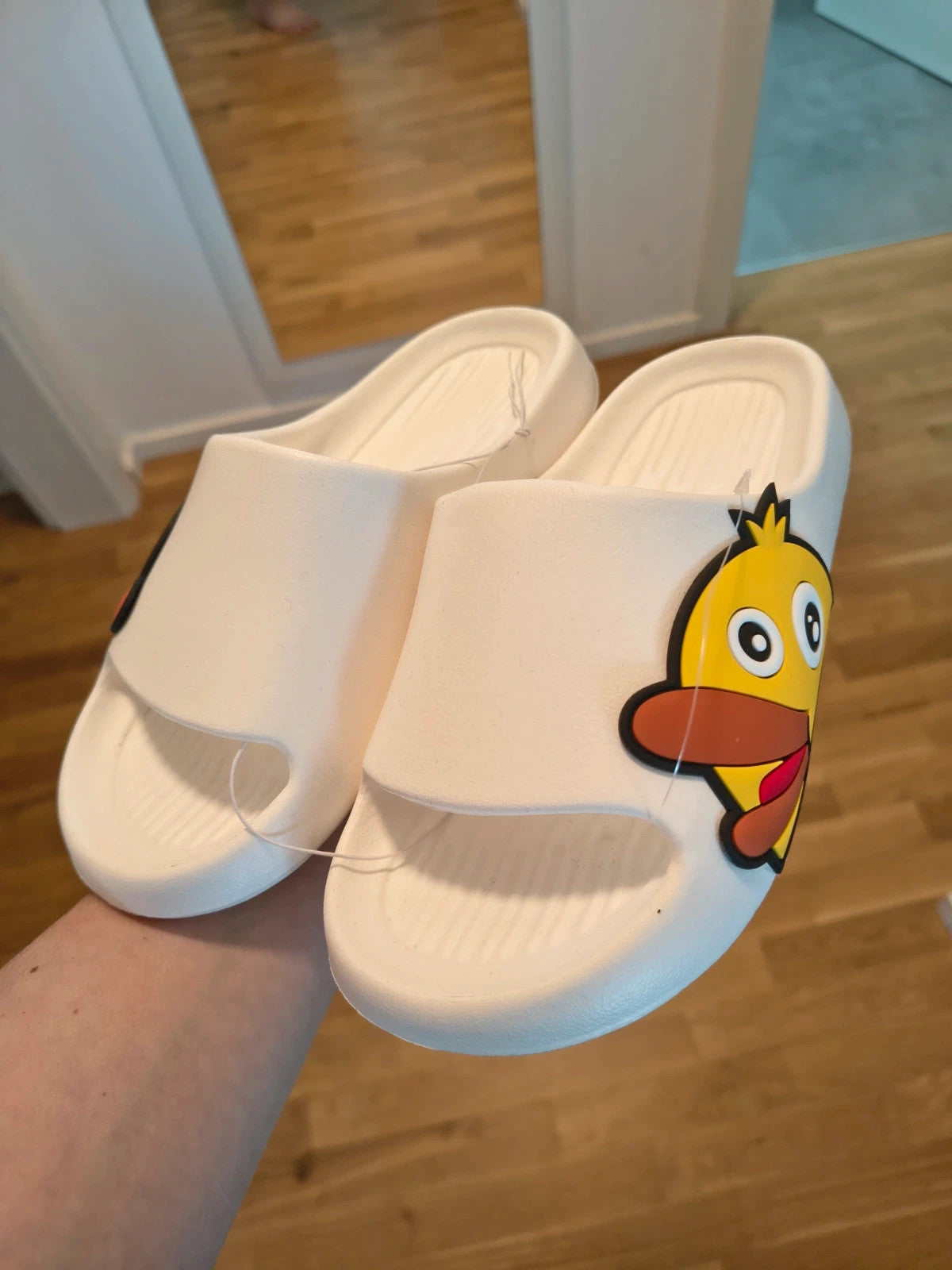 Slipper white and yellow slides with cartoon print and synthetic material.