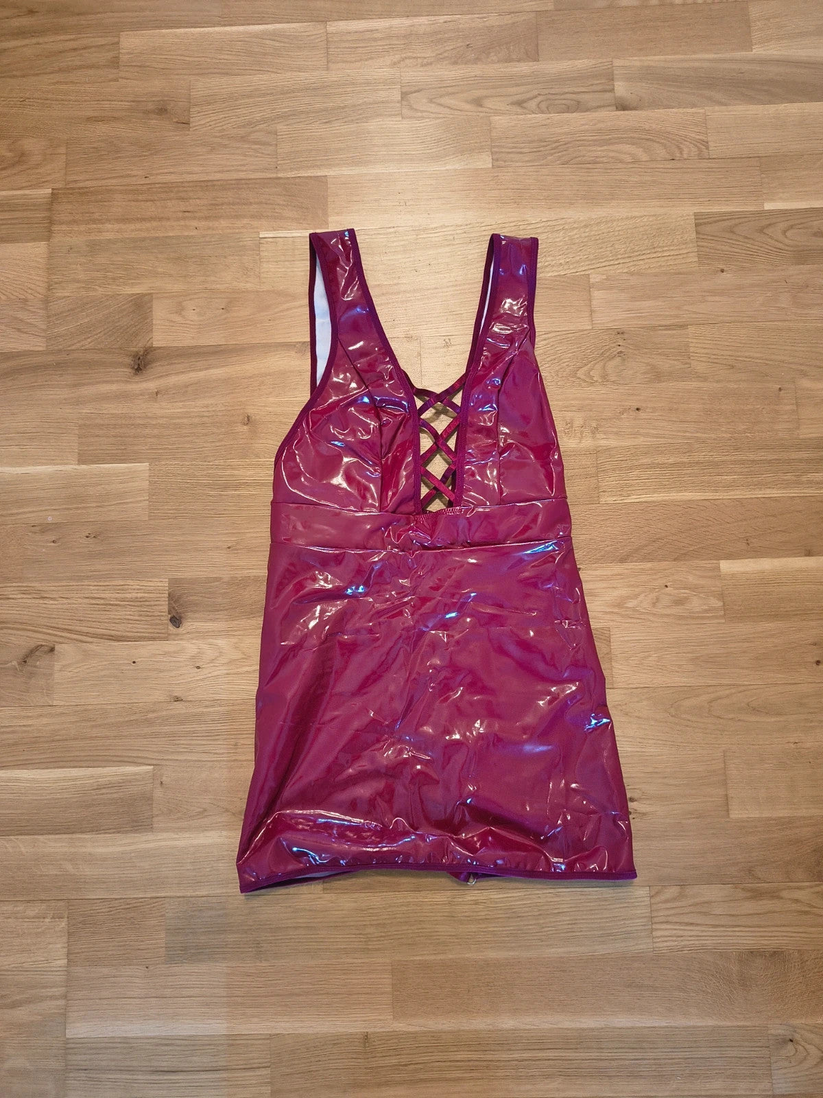Bordeaux burgundy bandage dress with lace-up detail and glossy vinyl appearance.