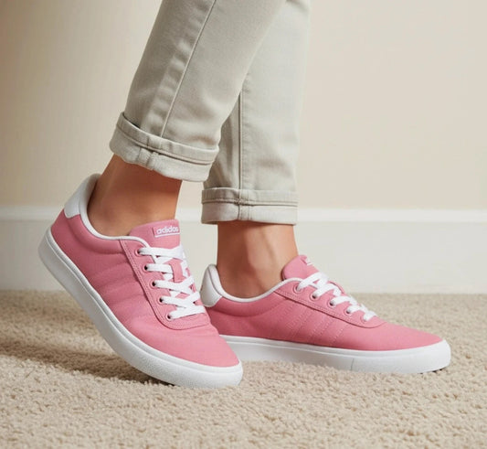 Adidas pink and white trainers with synthetic and textile materials, classic design.