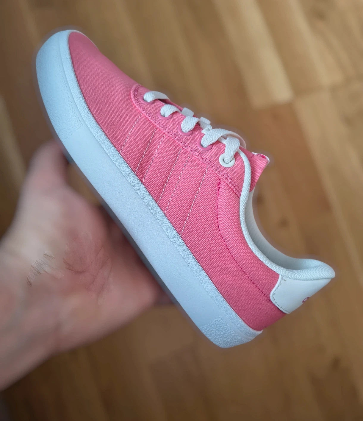Adidas pink and white trainers with synthetic and textile materials, classic design.