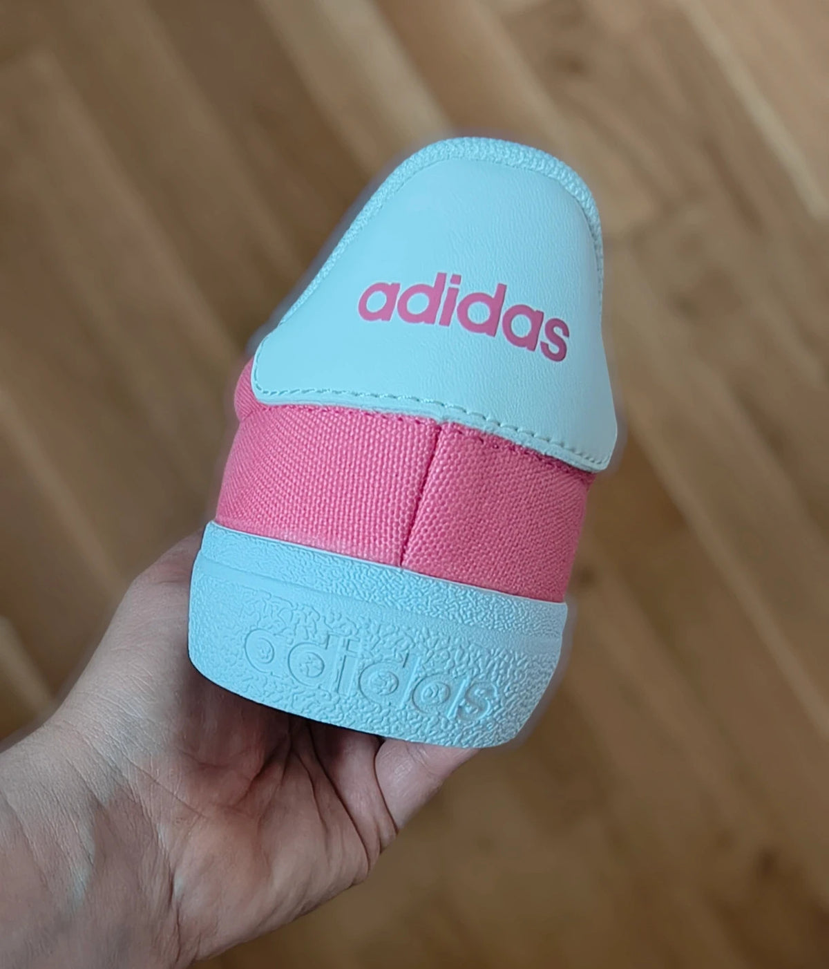 Adidas pink and white trainers with synthetic and textile materials, classic design.