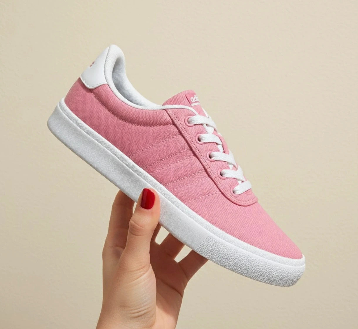 Adidas pink and white trainers with synthetic and textile materials, classic design.