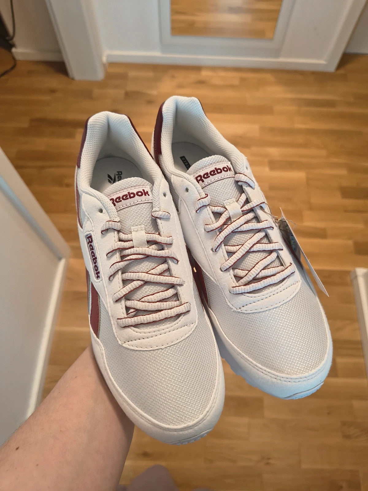 Reebok white trainers with synthetic and textile materials, featuring classic design elements.