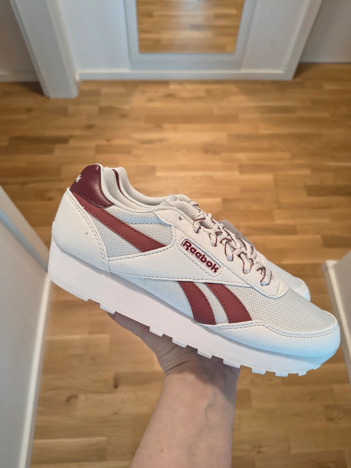 Reebok white trainers with synthetic and textile materials, featuring classic design elements.