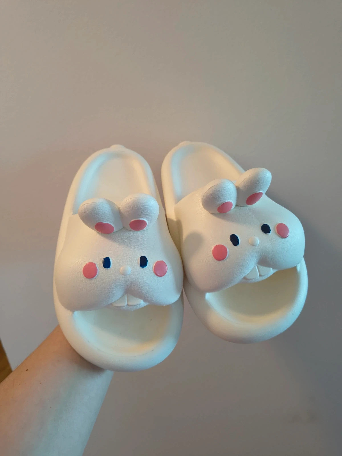 Slipper cream slides synthetic material with cartoon comic design and lightweight construction.