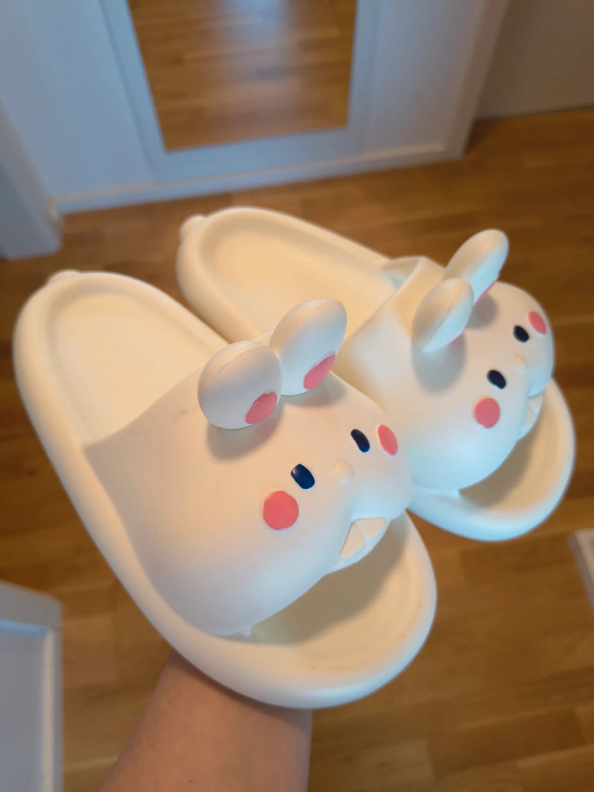 Slipper cream slides synthetic material with cartoon comic design and lightweight construction.