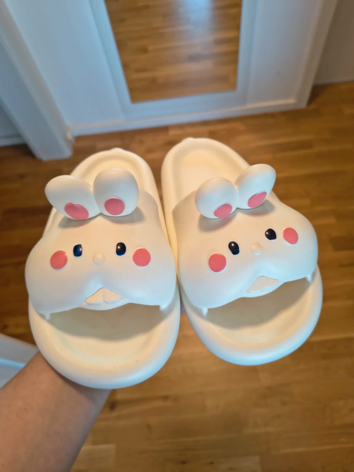 Slipper cream slides synthetic material with cartoon comic design and lightweight construction.