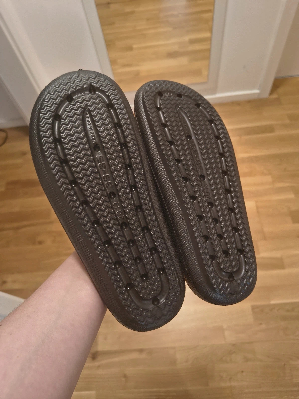Schwarze Slipper mit zwei verstellbaren Schnallen, leichtes Synthetikmaterial, strukturierte Innensohle.