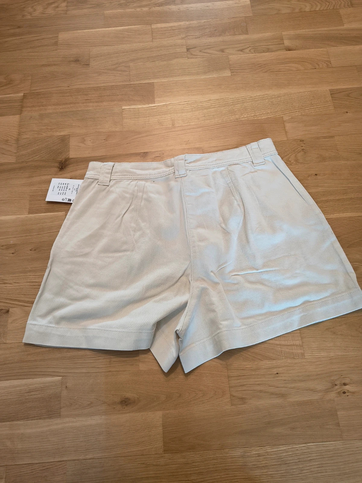 Only beige shorts high-waisted with button closure and decorative flap pockets.