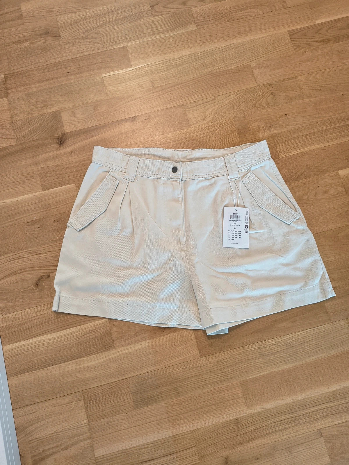 Only beige shorts high-waisted with button closure and decorative flap pockets.