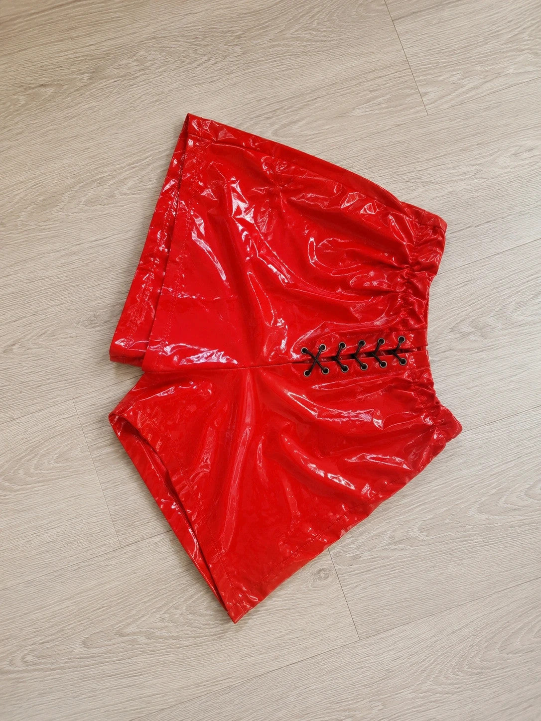 Red pajama shorts with shiny wet look and black lace-up detail.