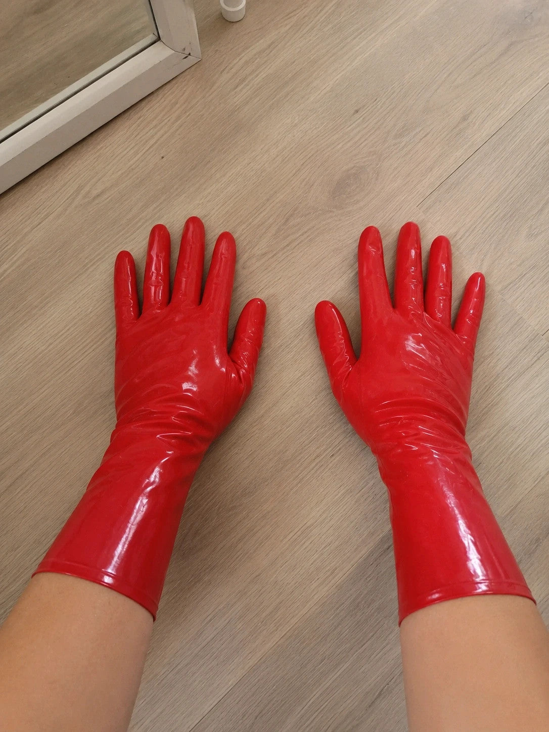 Herren red latex gloves with shiny finish, long design, form-fitting style.