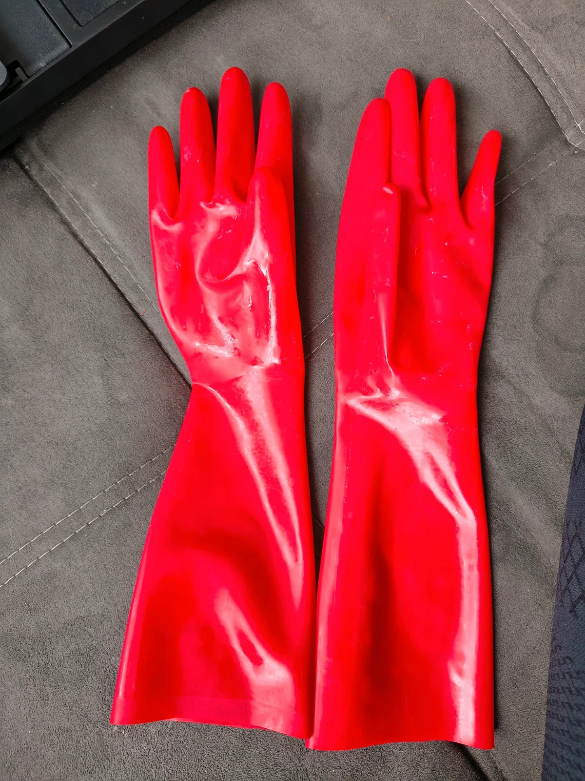 Herren red latex gloves with shiny finish, long design, form-fitting style.