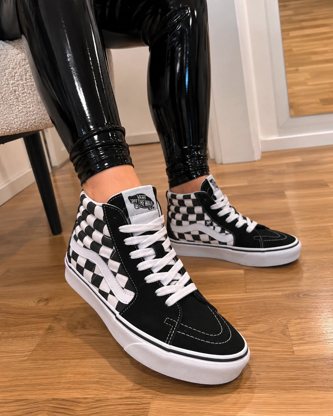 VANS black and white checkerboard high-top trainers with classic side stripe and leather material.