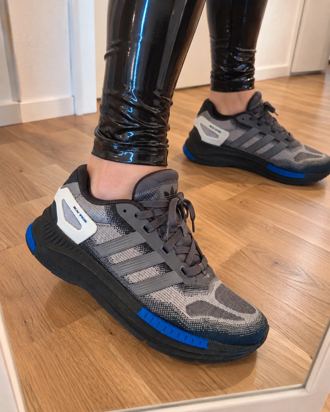 Adidas trainers grey black with blue accents, sporty design and distinctive sole.