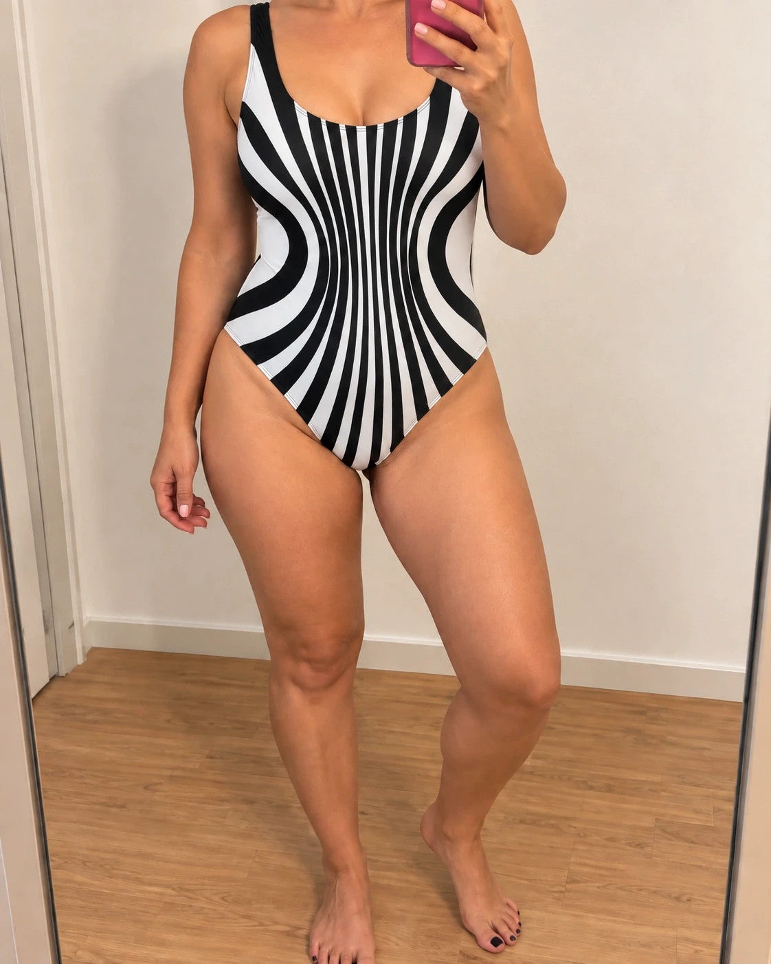 Muster one-piece swimsuit black and white with bold striped pattern and deep back cut.