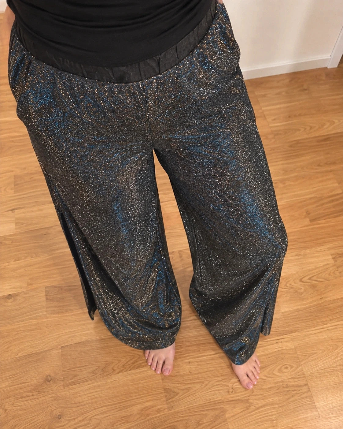 SheIn black and silver glitter flared pants with side slits and shimmering fabric.