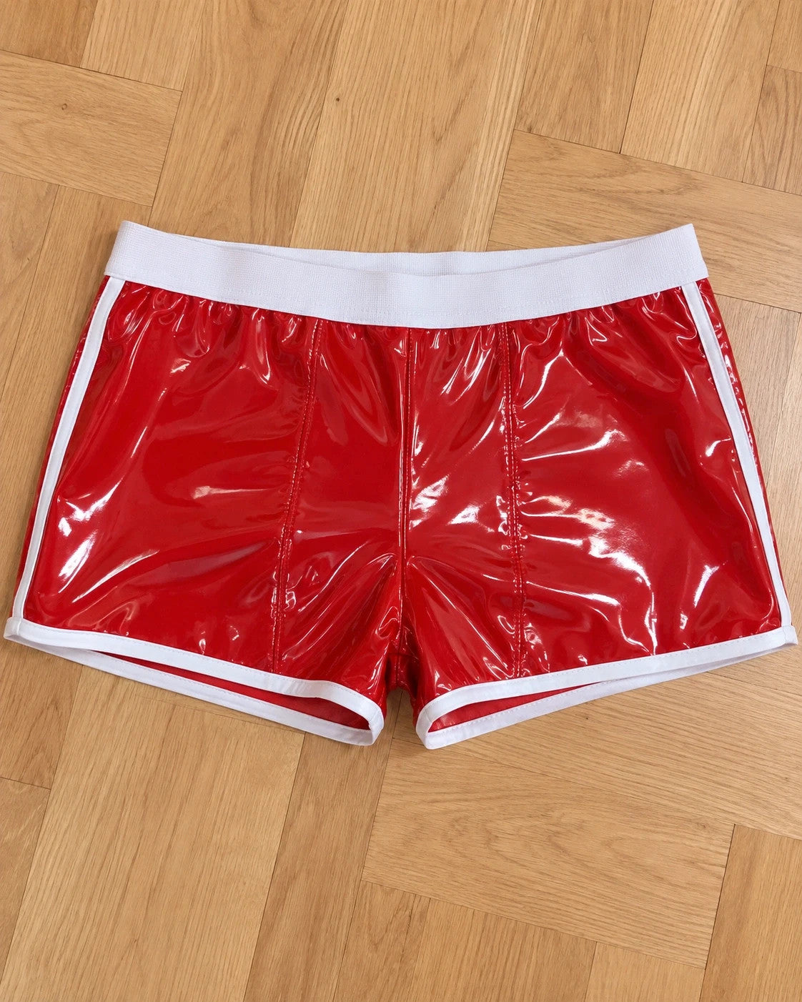Herren red shorts glossy finish with white contrast details and elastic waistband.