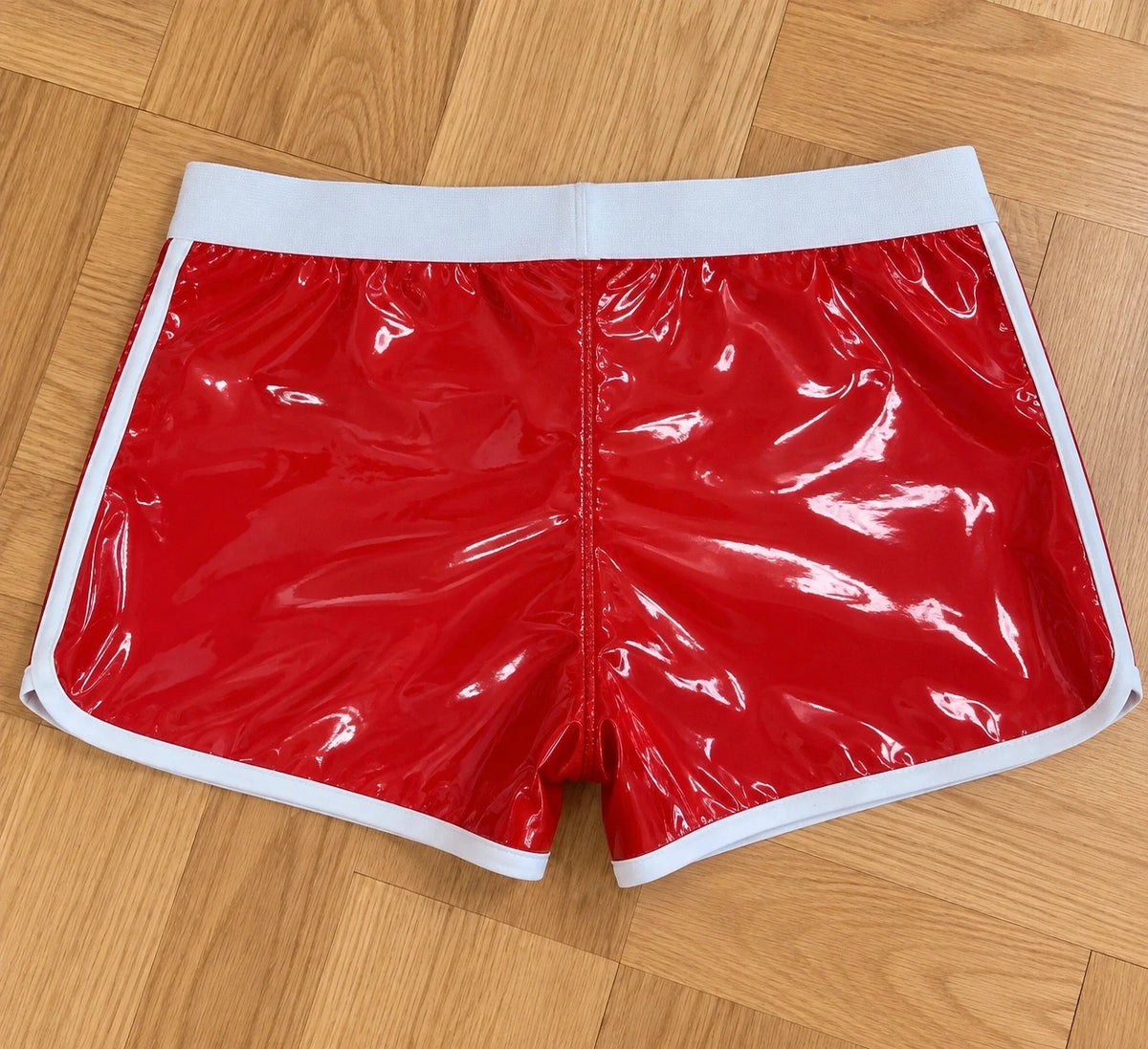 Herren red shorts glossy finish with white contrast details and elastic waistband.