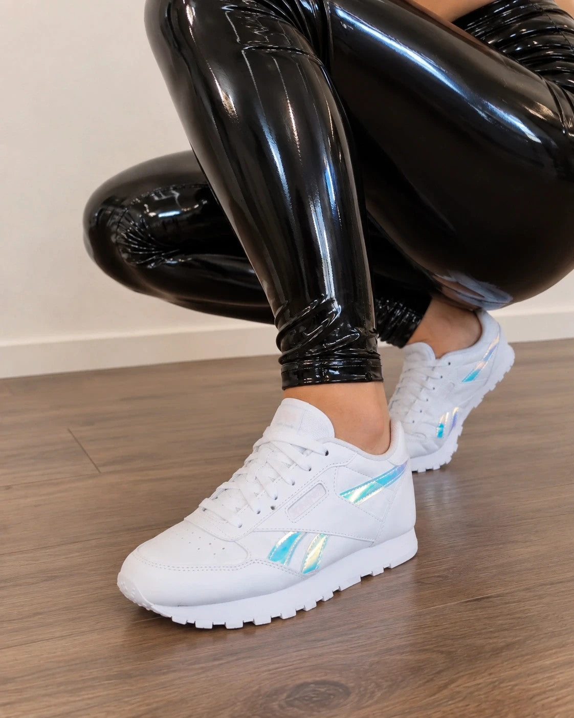 Reebok white trainers hologram details, synthetic material, classic logo design.