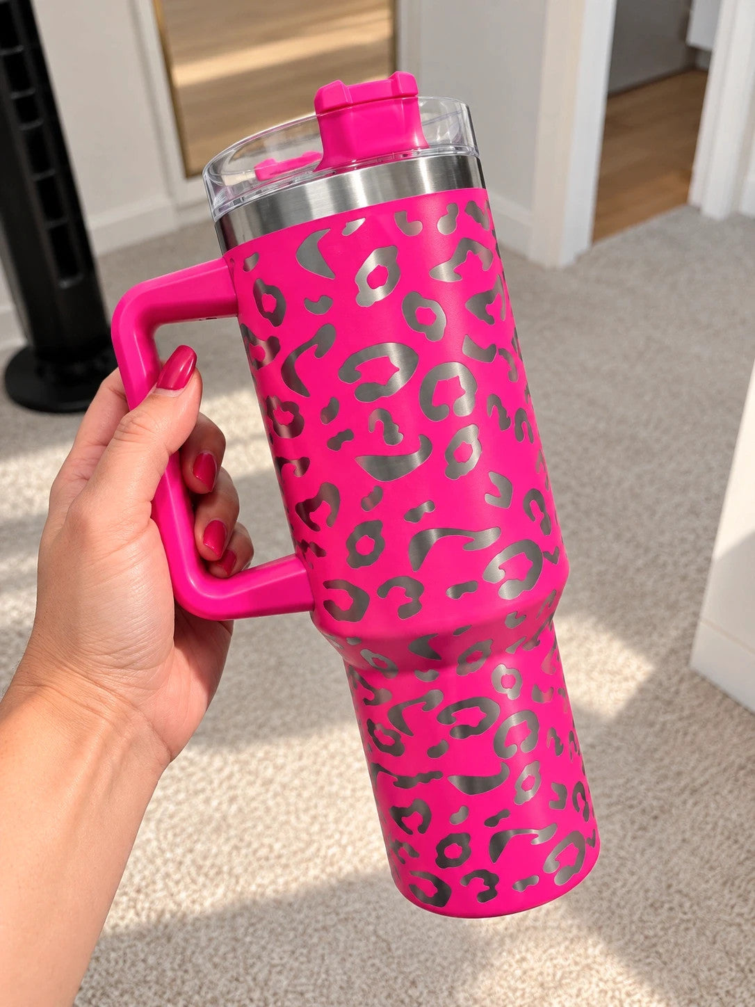 Pink tumbler with leopard print design, insulated, featuring handle and matching lid.