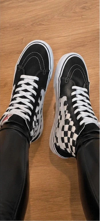 VANS black and white checkerboard high-top trainers with distinctive platform sole and logo.
