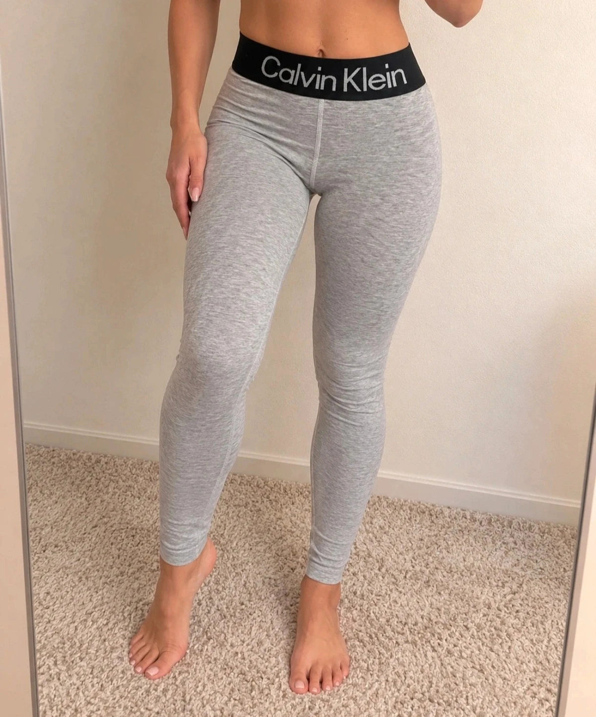 Calvin Klein grey bicycle tights with wide black logo waistband, fitted design.