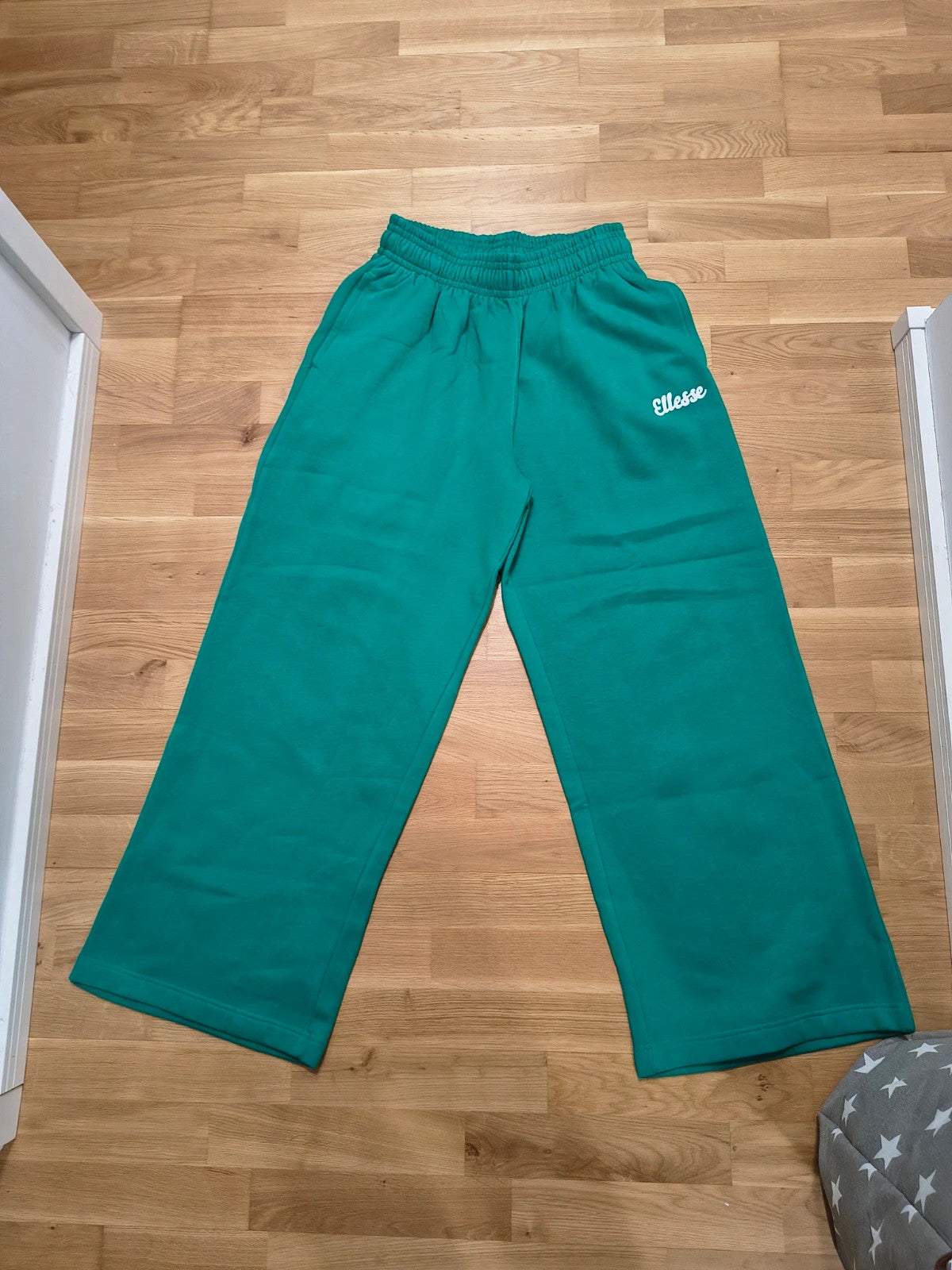 Ellesse green wide-leg jogging pants with logo, elastic waistband, and side pockets.