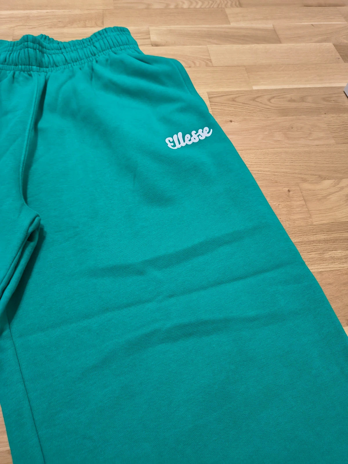 Ellesse green wide-leg jogging pants with logo, elastic waistband, and side pockets.