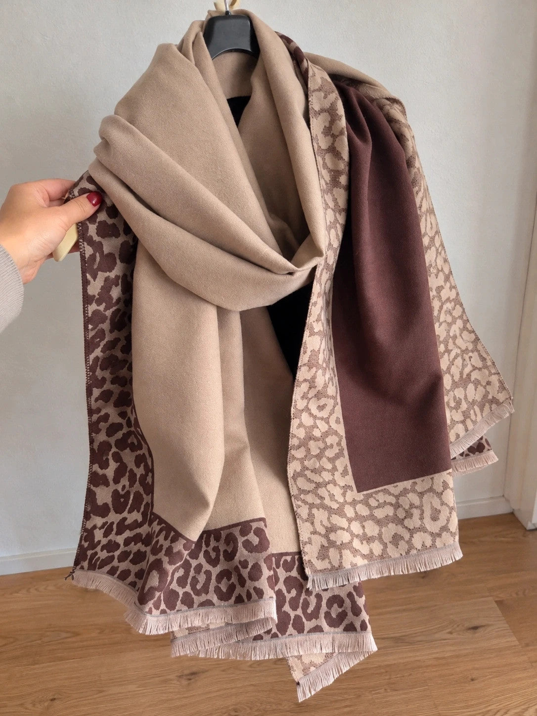 Beige scarf with brown leopard print edges and decorative fringes, reversible design.