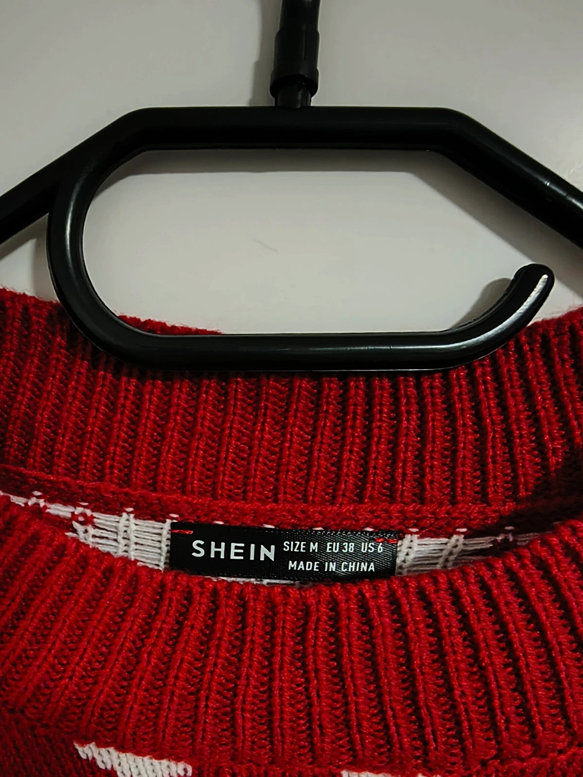 SheIn red and white Christmas sweater with reindeer, snowflakes, and ribbed cuffs.