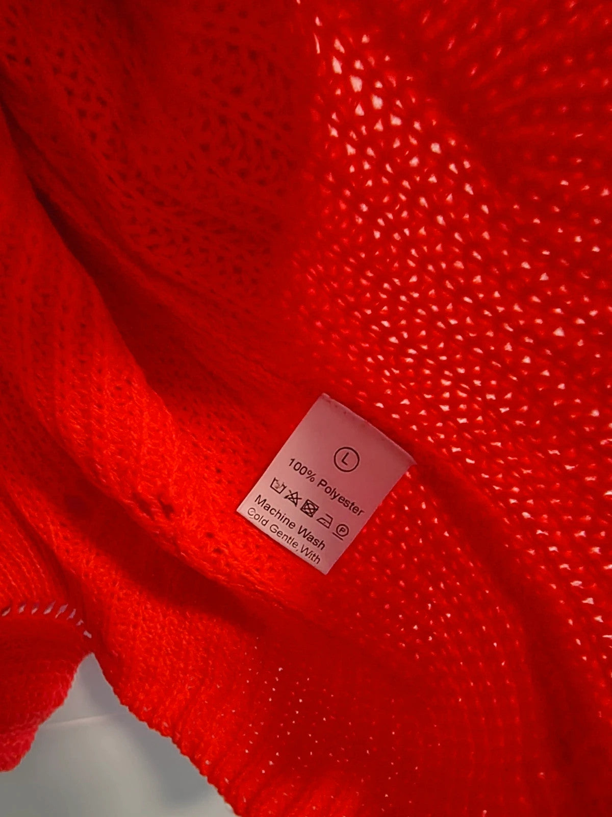Pullover orange pink oversized sweater with decorative knit pattern and hole details.