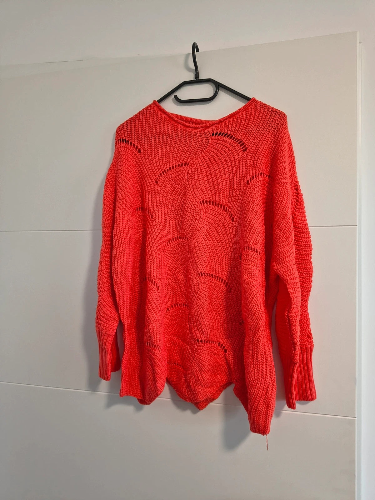 Pullover orange pink oversized sweater with decorative knit pattern and hole details.