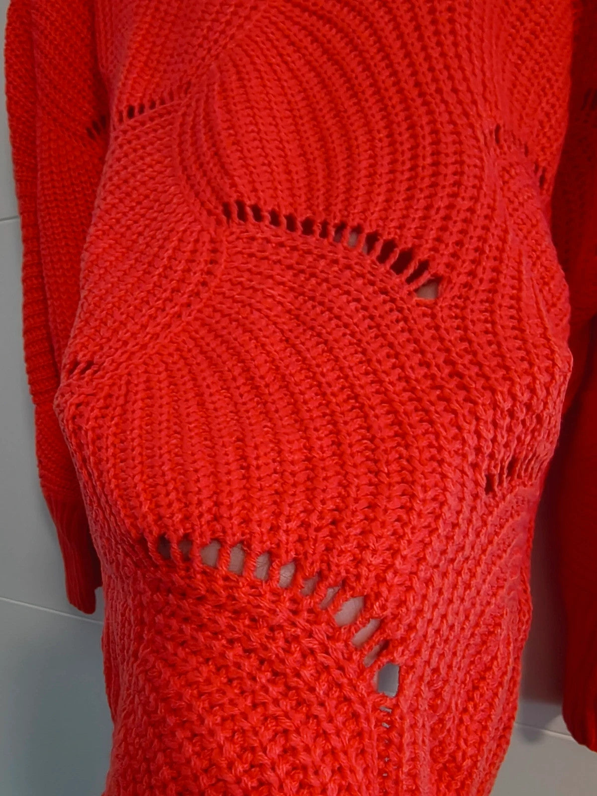 Pullover orange pink oversized sweater with decorative knit pattern and hole details.