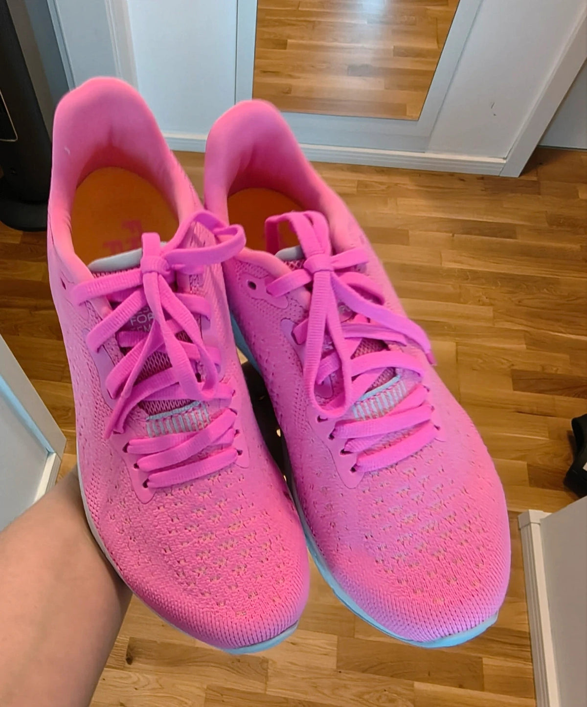 New Balance pink sneakers with white soles and contrasting logo, breathable textile material.