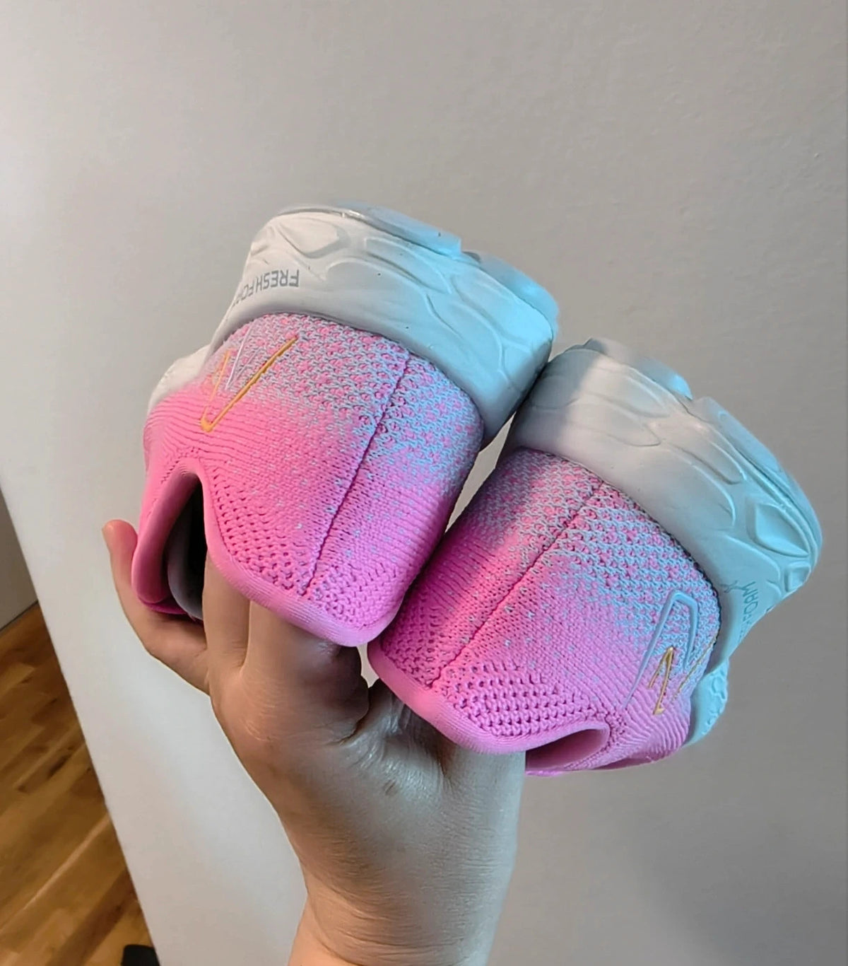 New Balance pink sneakers with white soles and contrasting logo, breathable textile material.