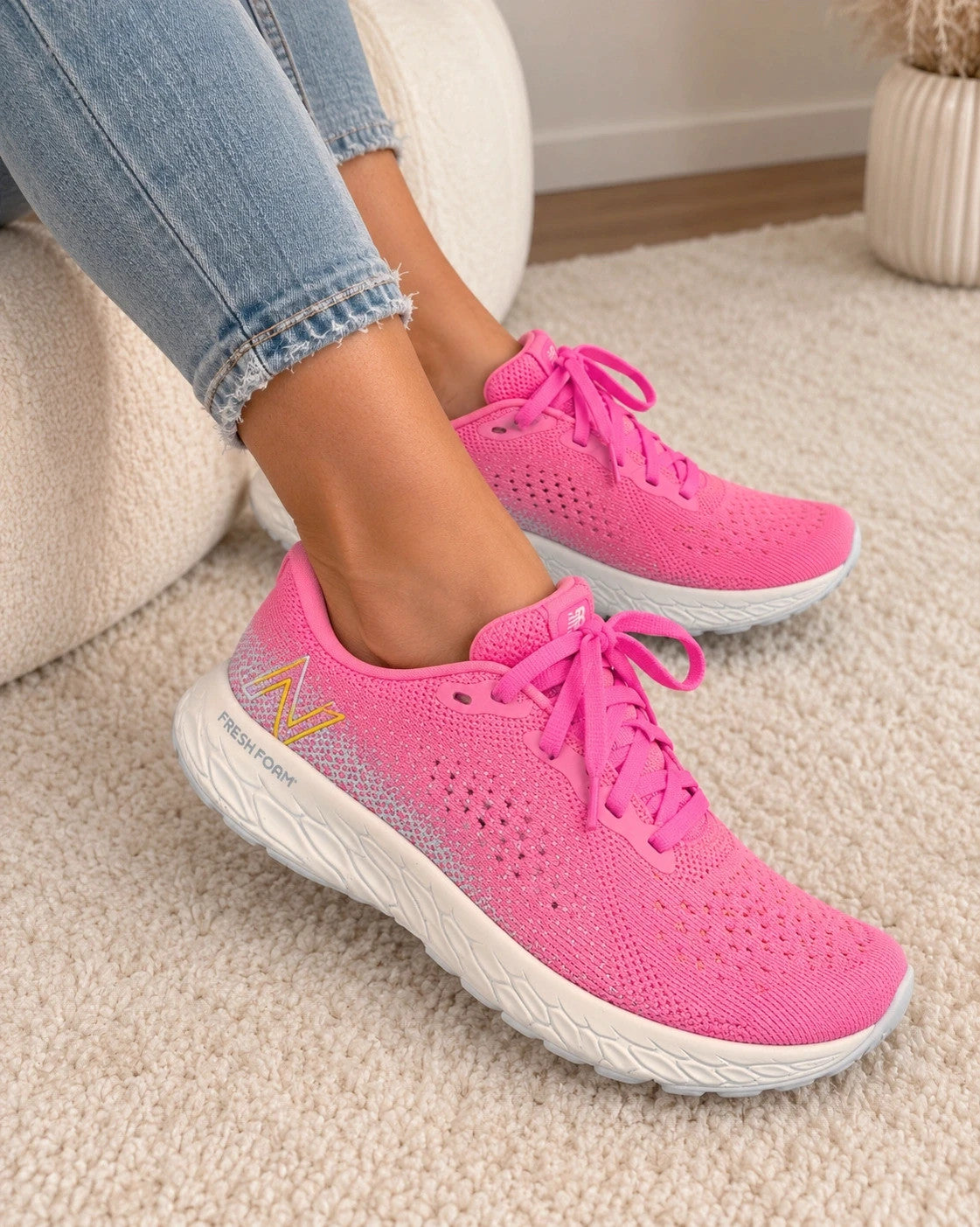 New Balance pink sneakers with white soles and contrasting logo, breathable textile material.