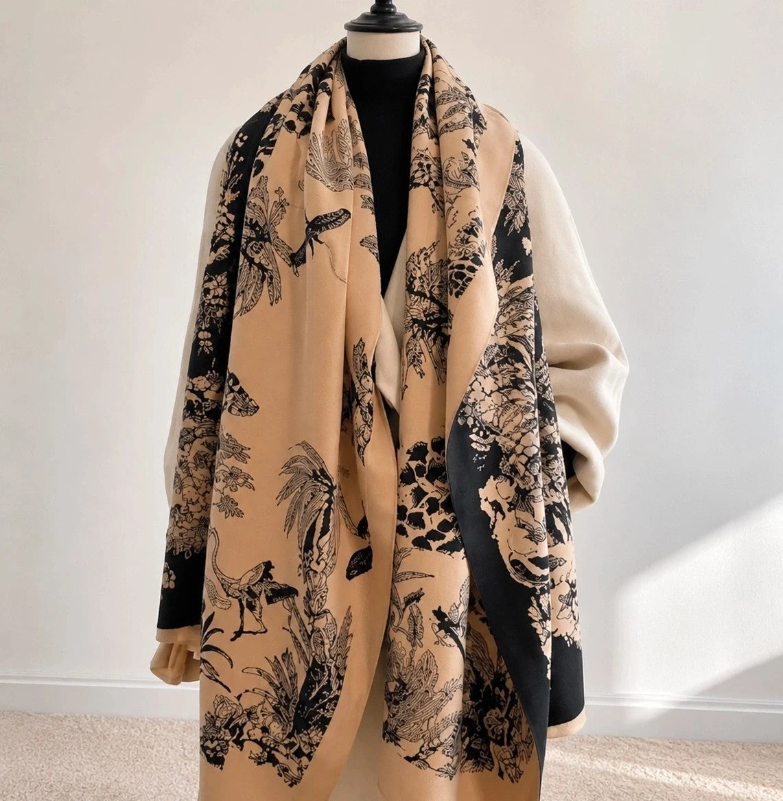 Beige shawl with black floral pattern, soft polyester material, versatile design.