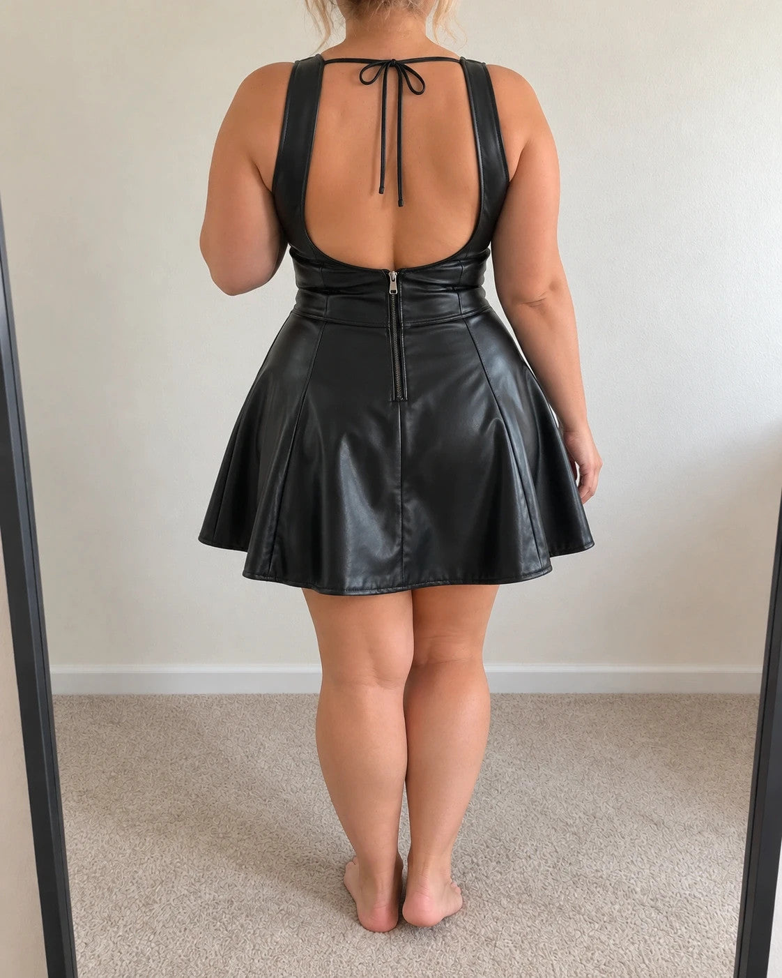 XXL black bandage dress with glossy leather look, deep V-neck, and open back.