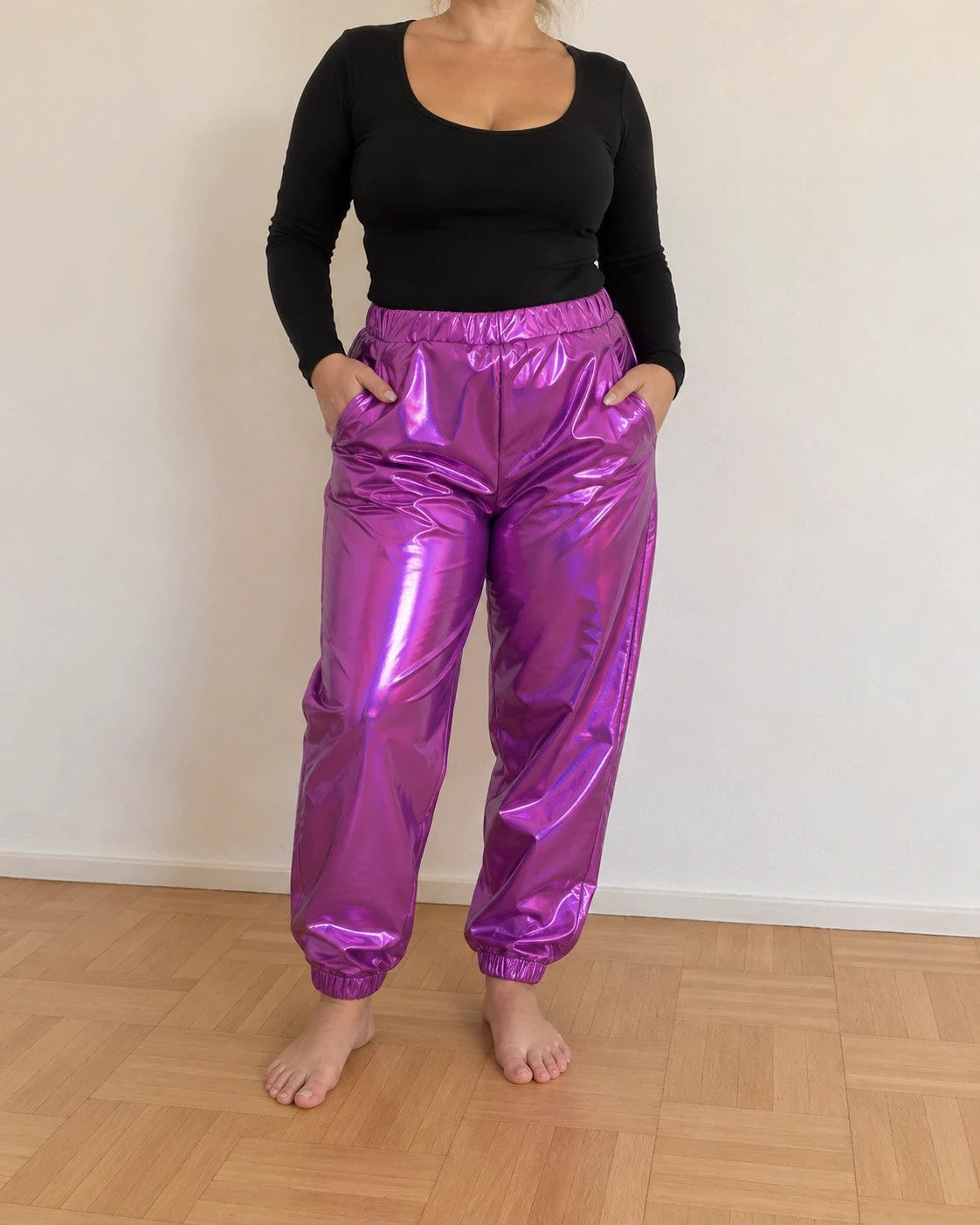 Lila purple jogging pants with shiny finish and fitted silhouette, featuring a smooth surface.
