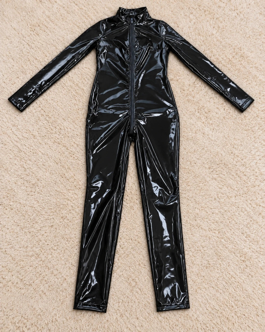 REI black jumpsuit with front zipper, fitted silhouette, and long sleeves.