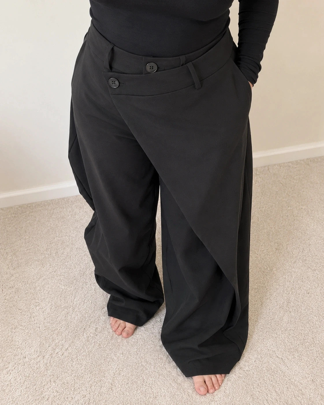 Wide leg black trousers with asymmetrical wrap design and overlapping waistband.