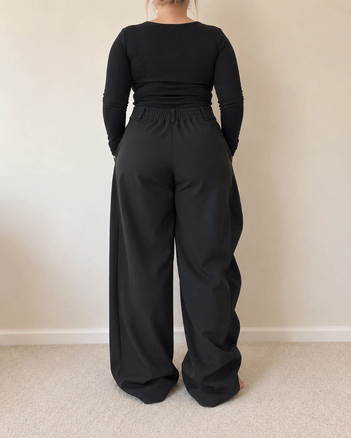 Wide leg black trousers with asymmetrical wrap design and overlapping waistband.