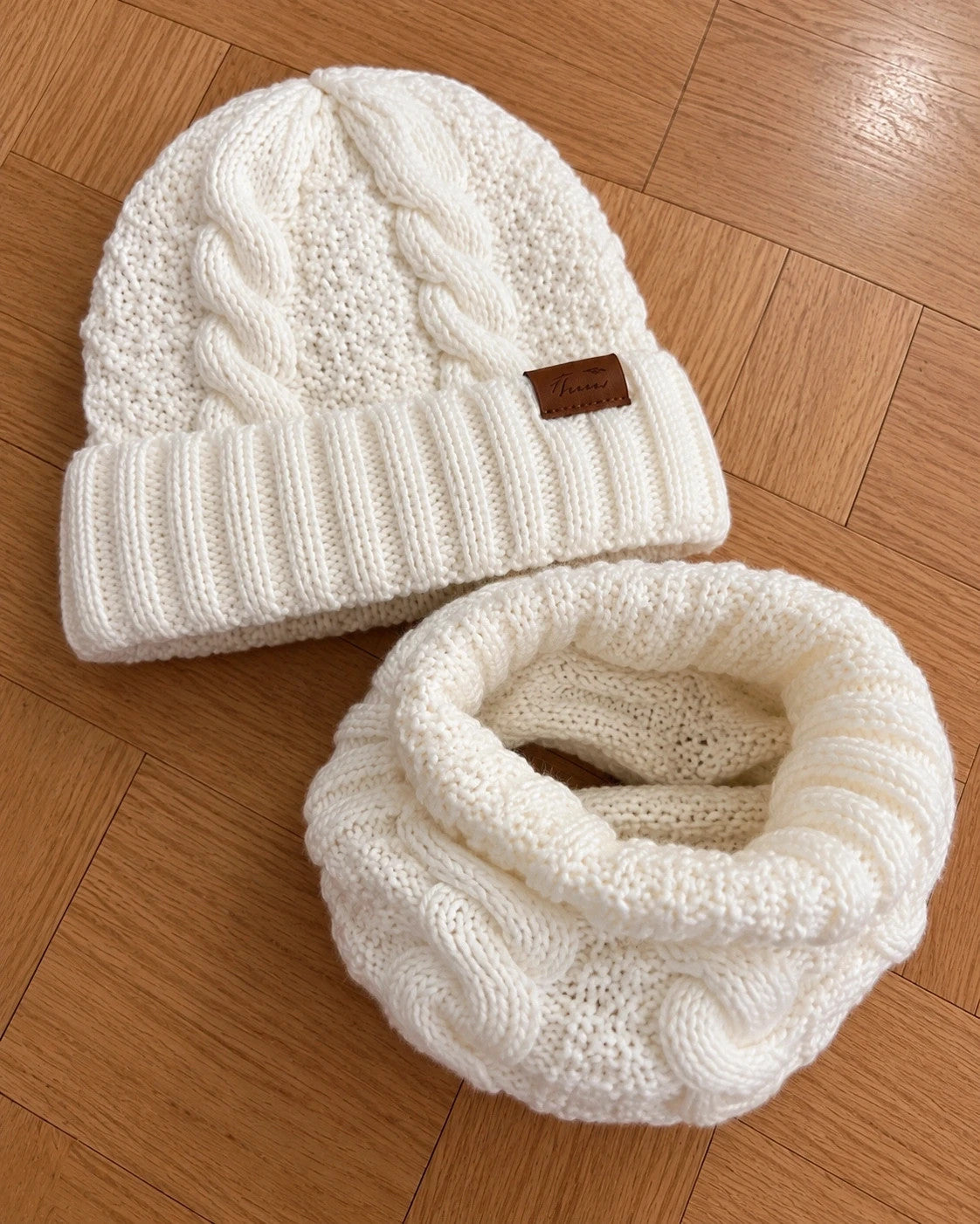 Off-White cream hat and neck warmer set with cable knit pattern, soft polyester material.
