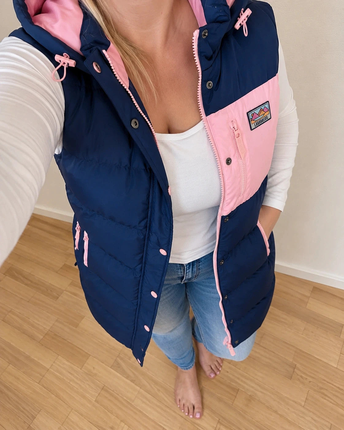 Lagooners navy vest with pink accents, quilted design, logo on chest, hooded.